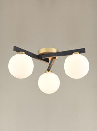 A black and gilt asymmetric light fitting. The three opaque globe lights sit on 3 black struts linked by gilt metal central rose. A really bright and contemporary pendant, adding an interesting, chic modern look to the smallest rooms