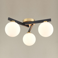 A black and gilt asymmetric light fitting. The three opaque globe lights sit on 3 black struts linked by gilt metal central rose. A really bright and contemporary pendant, adding an interesting, chic modern look to the smallest rooms