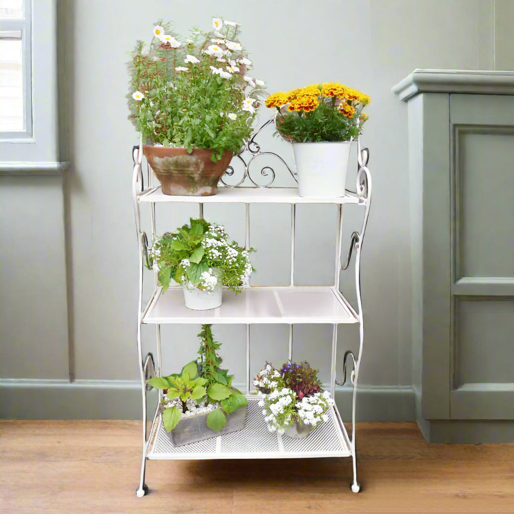 3 tier white folding shelf, great indoors or outdoors. With plants or books, this versatile little shelf can be placed anywhere, in any room, or folded neatly away when not in use.