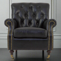 Classic black leather armchair, with cushion. Classic 'georgian style' leather chair on brass castor and wooden turned legs and trimmed with aged brass studs. Comfortable, well upholstered armchairs perfect for a period home.
H: 85 cm W: 78 cm D: 84 cm