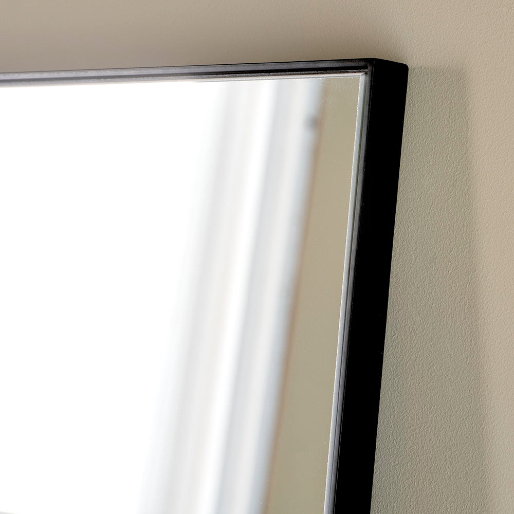 A simple and highly effective mirror minimalist in design yet maximum in impact.  With a super slim wooden black frame that is 2cm in depth, the striking thing about this mirror is the sheer volume of glass that reflects and bounces light back into your room.  Made in the UK, this mirror is worth the wait.  Also available in Gold.   H: 180 cm W: 90 cm D: 2 cm  Weight: 26 kg  Material: Wood  Made to Order with a lead time of 3-4 weeks. 
