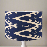 A dark blue cotton ikat patterned lampshade on a white stand.