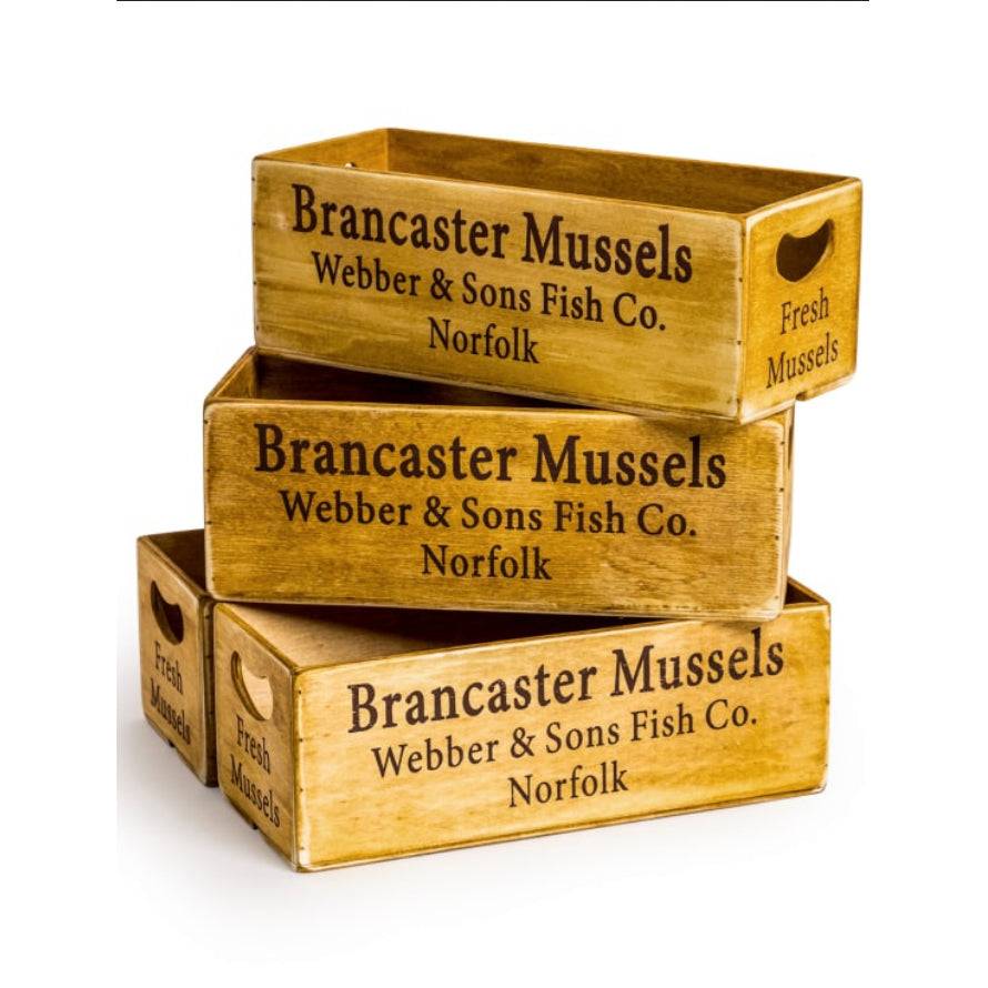 Vintage Wooden Storage Crates – Brancaster Mussels Design
Add rustic charm and functional style to your space with these vintage-inspired wooden storage crates.
Perfect for use at home, in the kitchen storing fruit, tea, or condiments, in a window sill with aromatic herbs, or in a hallway storing keys or sunglasses, these crates effortlessly blend form and function.