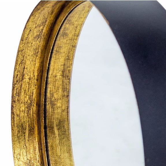 Close-up of a bronze deep frame mirror showcasing the textured gilt finish and sleek black backing.