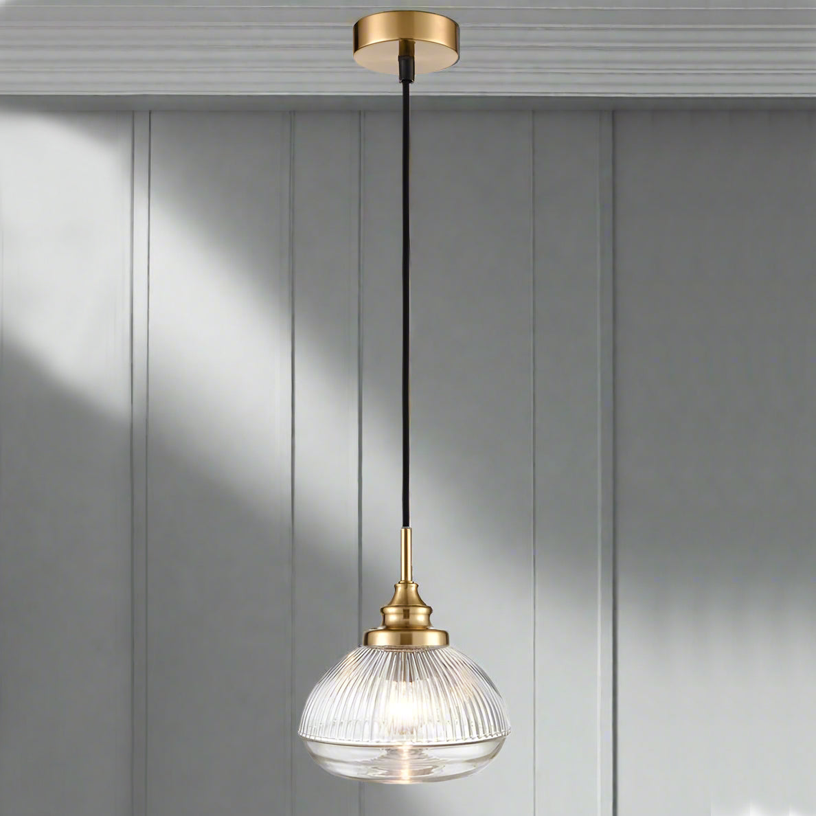 A ribbed glass pendant on beautifully designed brushed brass fittings. An unusual ribbed glass pendant on brushed gold metal with black flex, perfect hall, living room or kitchen light.
W: 18 cm H: 32 cm 