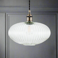 Ribbed glass and brass metal pendant light in an oval, pumpkin shape.  The ribbed glass acts to diffuse the light and gives an vintage feel to the space.  Great over a kitchen island or anywhere in the kitchen.