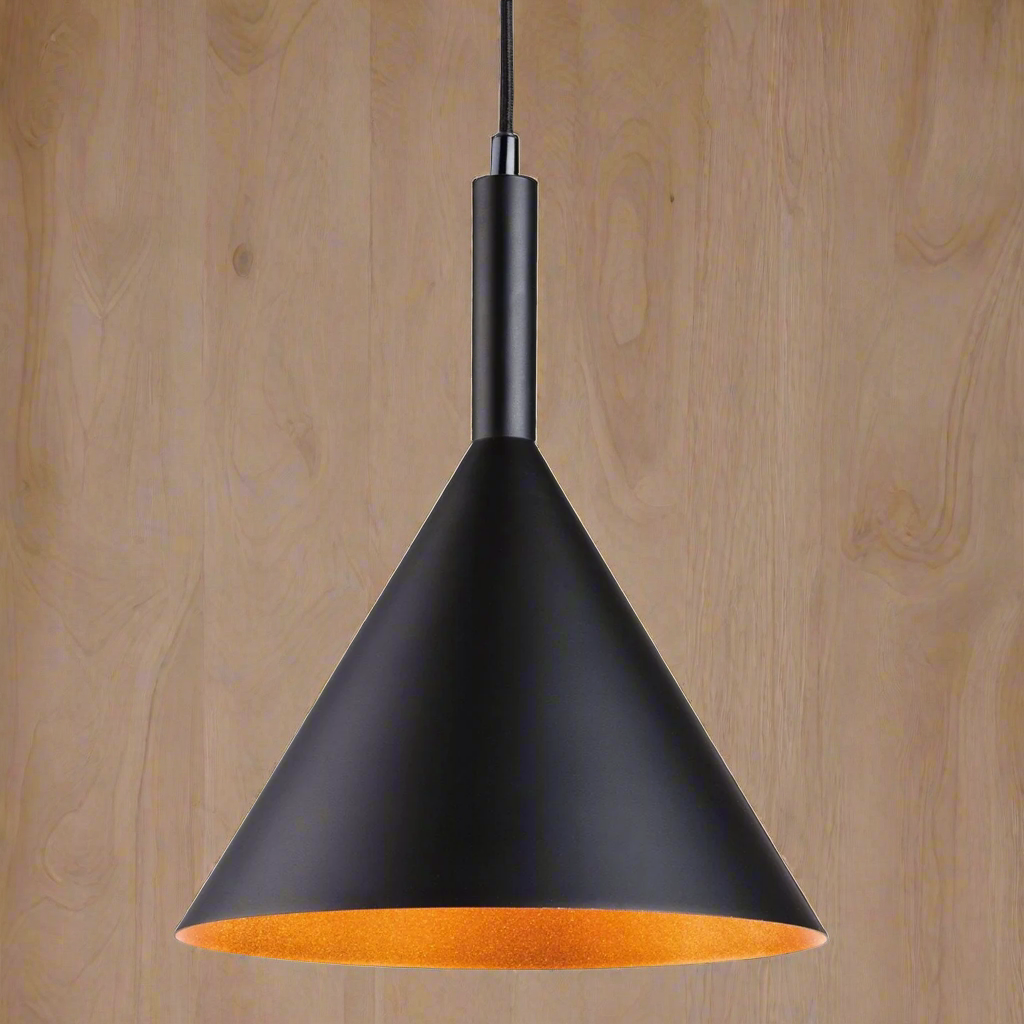 A conical metal pendant light with a gold/white inner, hanging from a ceiling on a wooden surface.