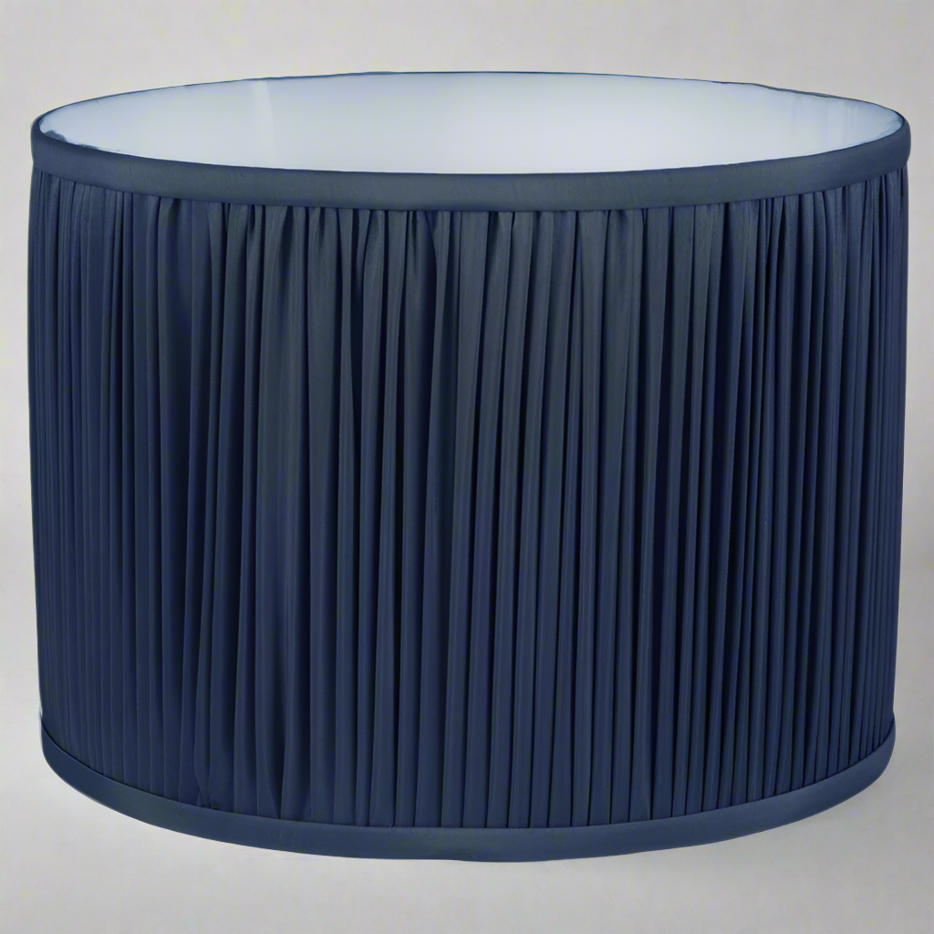 Dark blue pleated drum shades in a faux silk fabric in varying size.  A really classic pleated shade that would suit an antique column lamp or a contemporary glass based lamp beautifully.  The white inner will allow a bulb to shine through and illuminate your space. 