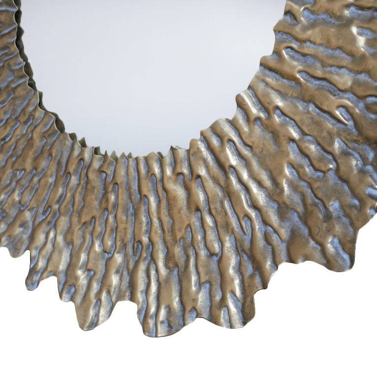 Large Round sun wall mirror with a distressed gold textured frame. The shape adds a touch of movement to its design. The distressed gold finish gives an antique feel