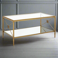 Empire style gilt metal and glass coffee table with metal cross medallion ends. This classic table will work well in a traditional or ultra contemporary setting. The mixture of the gilt metal and glass makes for a beautiful light and airy yet substantial piece of furniture.
