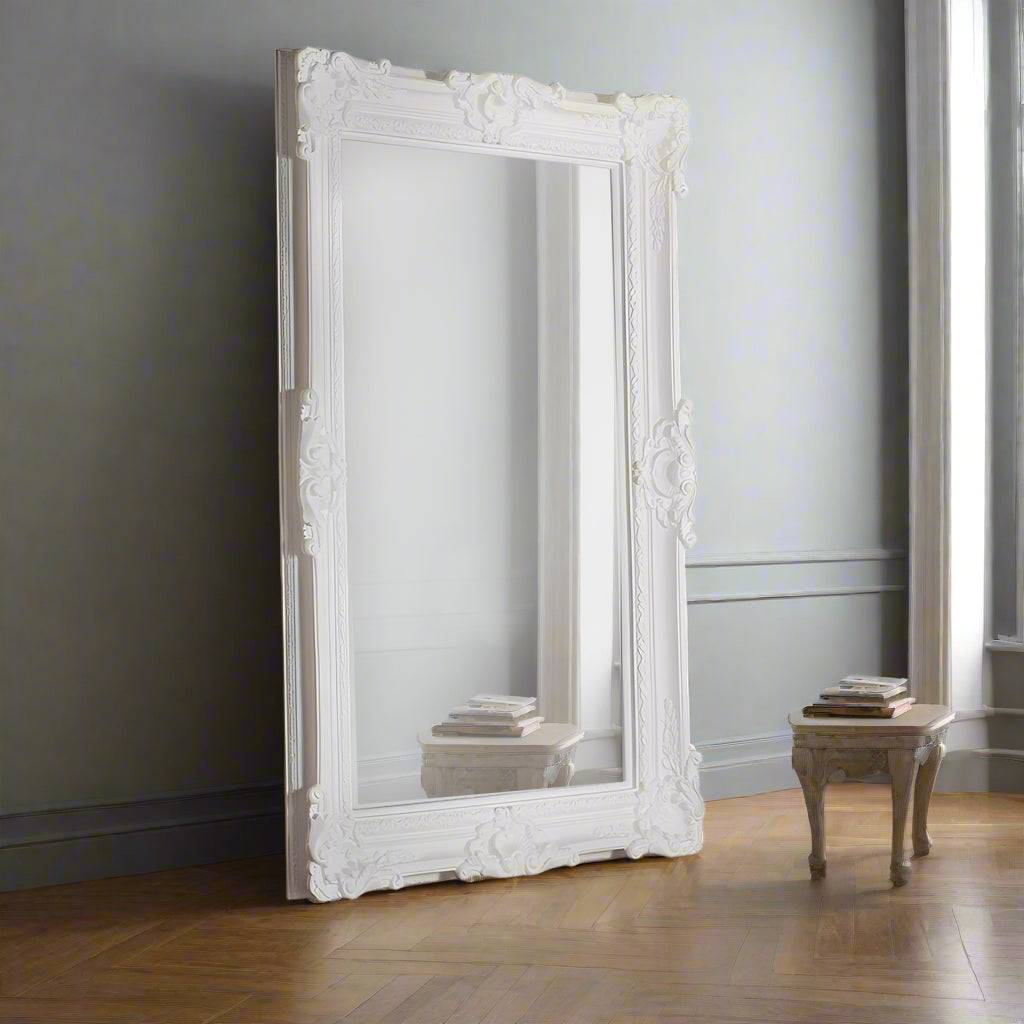 A large classic ornate white mirror to fill a entire wall and bring light and space into a room. Heavy, decorative famed 'Louis' style mirror.
