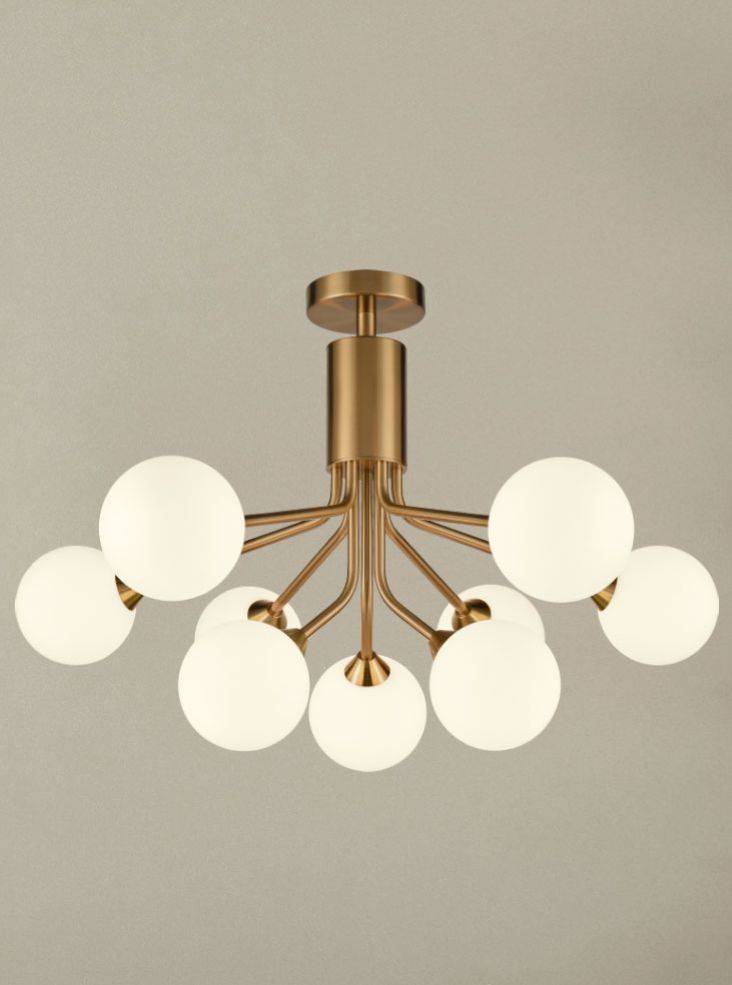 A stunning statement light that diffuses ample light around your home.  Nine opaque glass shades are suspended from beautiful brushed brass metal arms that are seamlessly attached to an adjustable or extendable brass rod