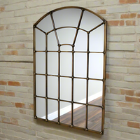 A great arched metal window mirror in an antique brass finish with studding to the frame. Like all window mirrors this one will give the impression that the room in which it hangs is larger and brighter.  An unusual colour and the studs on the frame adding an industrial feel. 