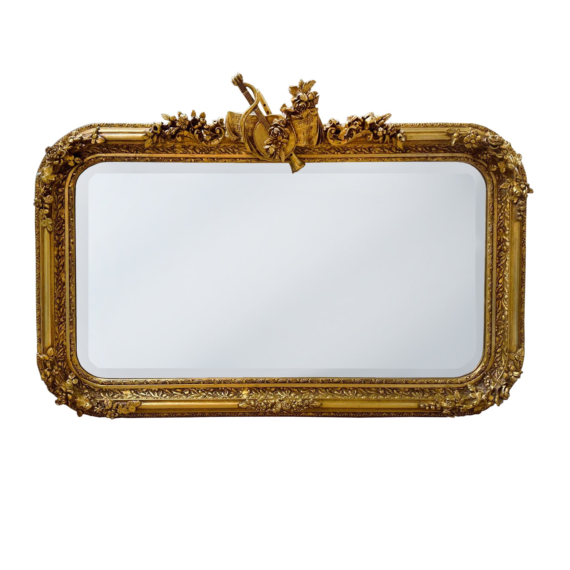 Make a grand statement with this exquisite Large Ornate Gold Overmantle Mirror, a luxurious piece designed to bring timeless elegance and opulence to your interior.
Crafted with intricate detail, the mirror features a richly carved frame adorned with floral garlands, scrollwork, and a central crest displaying classical motifs — evoking the romantic grandeur of the Louis XVI era. The generous rectangular shape, softened by elegantly curved corners, offers both functionality and decorative impact.
Over a fi