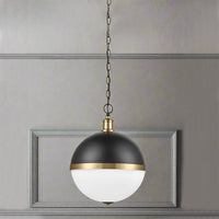 Round dark metal and opaque glass pendant with gilt accent to the centre on a gilt mount and chain.  A really unusual pendant light, exceptional style and perfect as a kitchen island light. The mixture of the black metal and opaque glass and the metal accents to the centre and top of the sphere add to the design led look of this pendant.