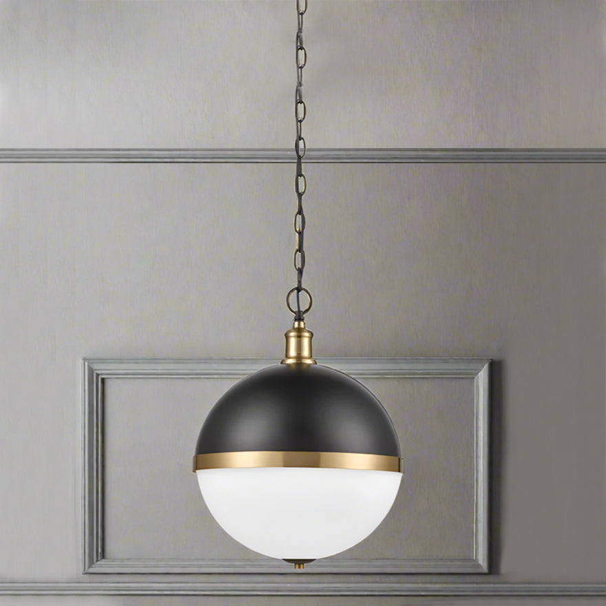 Round dark metal and opaque glass pendant with gilt accent to the centre on a gilt mount and chain.  A really unusual pendant light, exceptional style and perfect as a kitchen island light. The mixture of the black metal and opaque glass and the metal accents to the centre and top of the sphere add to the design led look of this pendant.