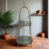 A unique and very pretty shelf unit with pierced metal detailing around the shelves which can be lifted out and also used as trays.  Finished in a rustic antique gold colour, this metal unit has two shelves encased in an outer frame that can fold flat.  
This is useful storage with a Moroccan vibe for small spaces that will quickly declutter your home.  Can be used in every room and looks particularly glamorous in bathrooms and conservatories. 