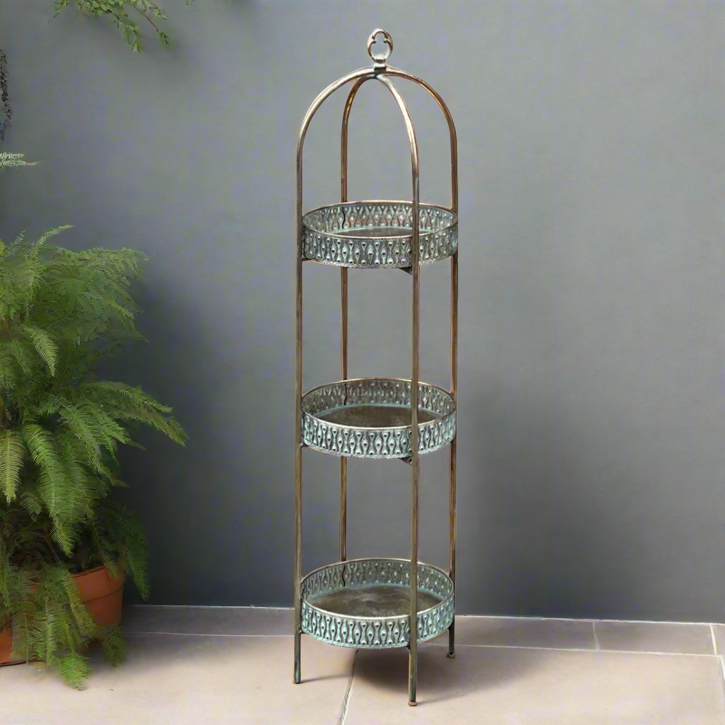 A unique and very pretty shelf unit with pierced metal detailing around the shelves which can be lifted out and also used as trays.  Finished in a rustic antique gold colour, this metal unit has three shelves encased in an outer frame that can fold flat.  
This is useful storage with a Moroccan vibe for small spaces that will quickly de-clutter your home.  Can be used in every room and looks particularly glamorous in bathrooms and conservatories. 