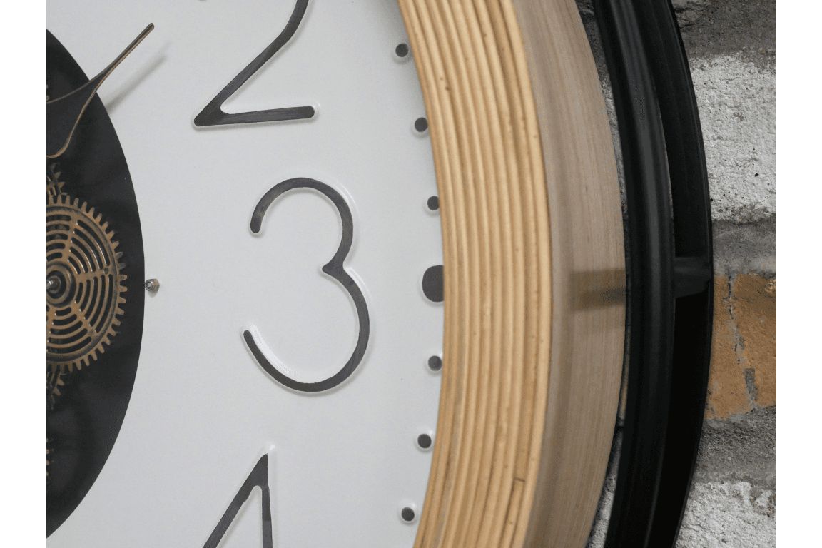 A large moving cog clock with white enameled face and pale wooden surround. The entire cog clock is encased in a iron frame. A statement clock which will enhance any wall