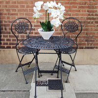A folding oval garden furniture table and two matching folding chairs in a powder coated iron finish, which allows for weather resistance and durability.  The table  features a decorative lattice work top, the same pattern on the matching chairs.  The three piece set is a perfect size for a smaller garden and great on a patio or balcony.
Enjoy al fresco dining with this bistro set.