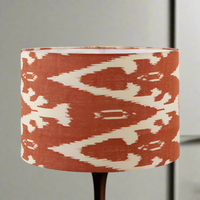 A red cotton ikat patterned lampshade on a stand, with a geometric design.