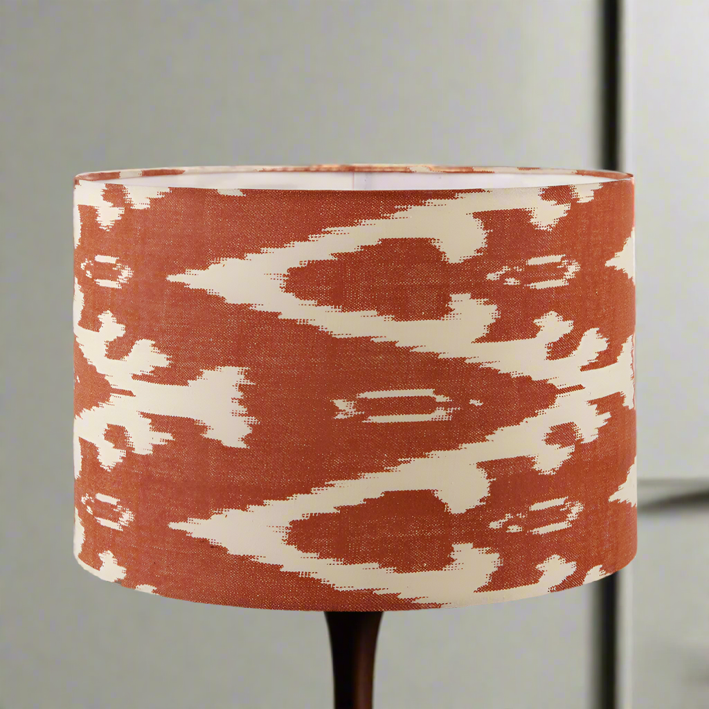 A red cotton ikat patterned lampshade on a stand, with a geometric design.