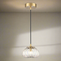 Glass ribbed pendant with aged brass metal accents, a beautiful pumpkin shape that would add style to any room.  Simple stylish glass pendant with brushed gold metal accents and twisted black flex.  Small but perfectly formed glass pendant, great for smaller cloakrooms, bedrooms, they would work well as bedside lamps.
W: 14 cm H: 21 cm 