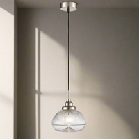 A ribbed glass pendant on beautifully designed satin nickel fittings. The hanging glass fitting with satin nickle metal accents would be a perfect over a kitchen island.