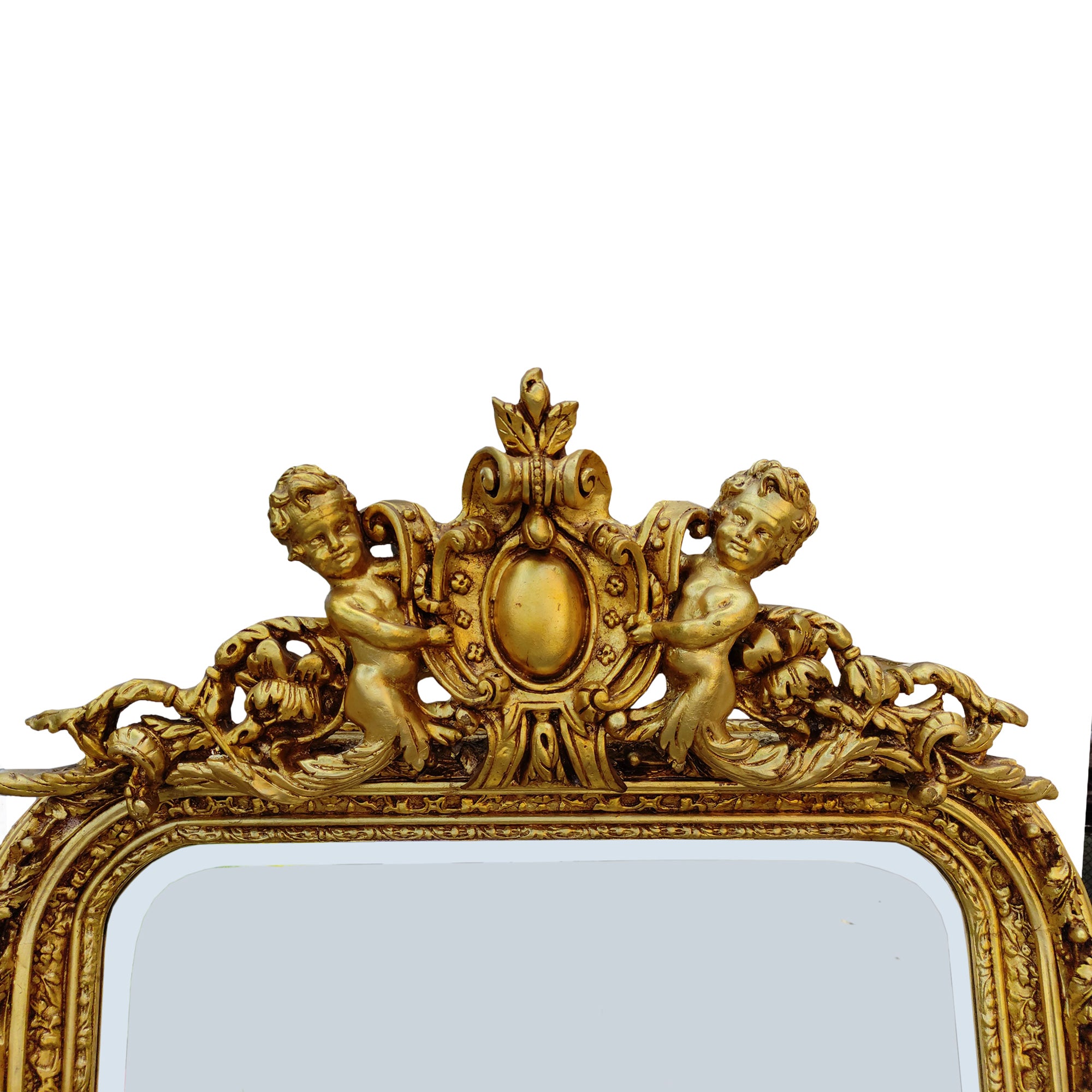 Ornate gilt wood ornate wall mirror, with carved frame and topped with a pair of cherubs holding a medallion. Highly decorative mirror in the 'Georgian' style, perfect in a hall, over a fireplace in a living room or as a stunning addition to your bedroom or dressing room.These ornate wall mirrors work well in a period country home as well as adding that luxurious touch to a town home. 
H: 180 cm W: 100 cm D: 16 cm