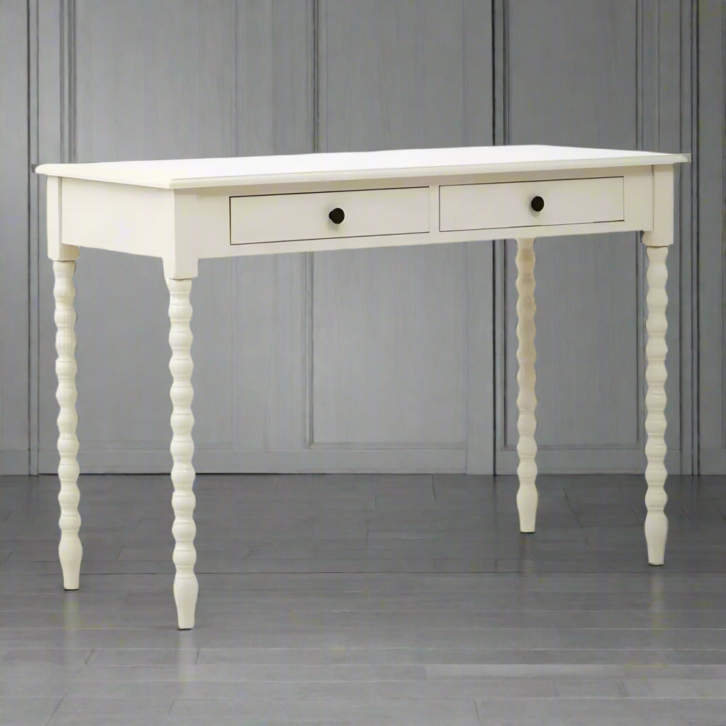 A pine desk painted in soft ivory with turned leg detail. Such a simple but so useful desk or dressing table in a Ivory paint finish The legs are turned in a spiral decoration. This piece of furniture would look perfect in a bedroom as a desk, in a living room or hall as a console.