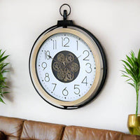 A large moving cog clock with white enameled face and pale wooden surround. The entire cog clock is encased in a iron frame. A statement clock which will enhance any wall