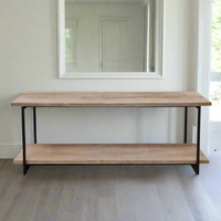 A long wooden console table with a black iron frame and a bottom shelf, placed against a wall with a mirror reflecting the opposite side.