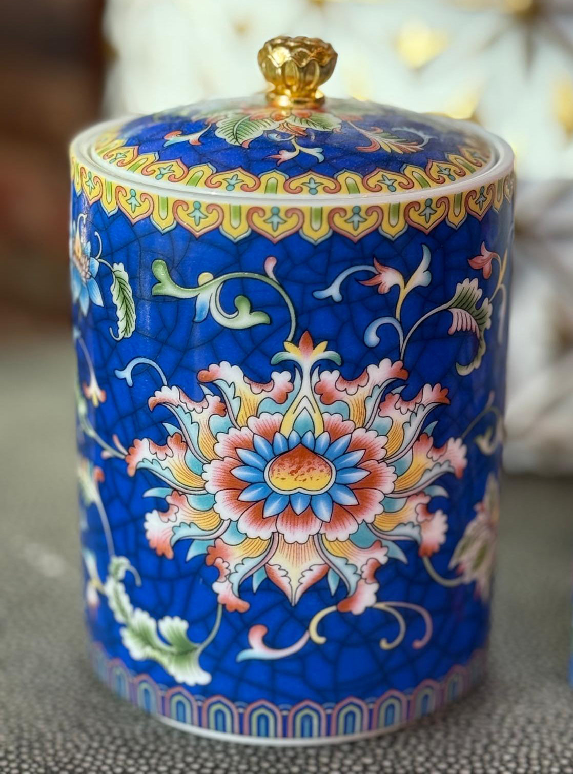 Handcrafted blue ceramic scented candle jar with floral design and gold detailing, scented with Black Cedar.