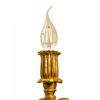 Gold cherub table light, perfectly formed cherubim hand outstretched holding a lamp.  The lamp looks best with the addition of a filament bulb to add a glow.  The lamp has a rococo decorative style working well in a luxurious bedroom, baroque styled living room - anywhere you need a touch of glamour.   So decorative but also perfectly functional.  