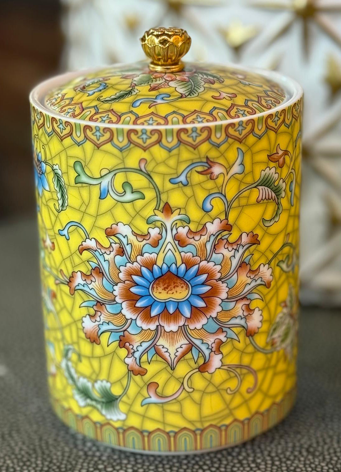 Handcrafted yellow ceramic scented candle jar with gold detailing and floral design, scented with Pineapple and Coconut.
