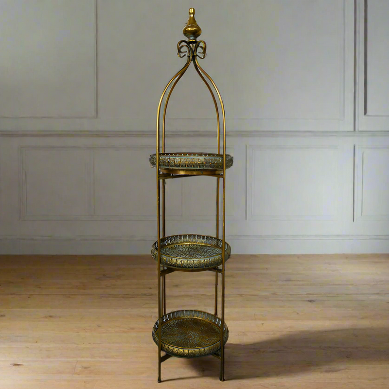 Moroccan style three tier folding stand in antique brass with galleried trays.&nbsp; &nbsp;Can be used in a kitchen, bathroom, anywhere in the house to display or use as extra storage. A great, authentic Moroccan look that works well in a period or eclectic interior.&nbsp; In a conservatory or on a patio covered in plants, bathroom for all those bathing accessories, this unit has so many uses.