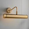 An antique brass picture wall light with a cylindrical shape and a rocker switch on the wall.