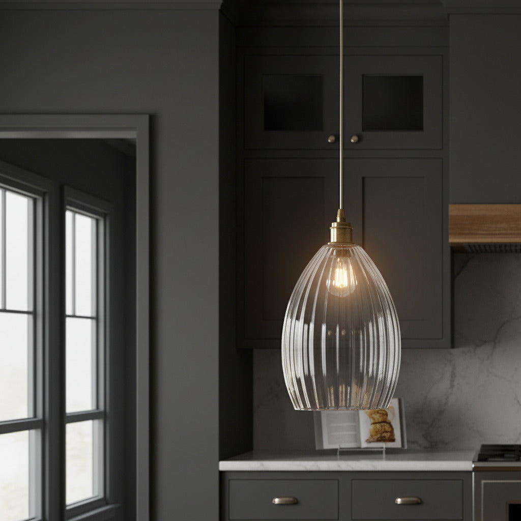 A long ribbed glass and antique brass metal pendant light. Perfect kitchen island light, or in a bedroom. Great in a hall will illuminate and add a glow to any room.