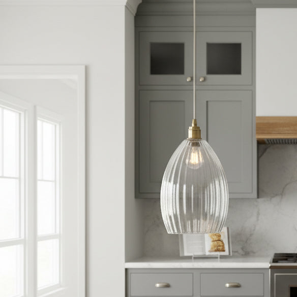 A long ribbed glass and antique brass metal pendant light. Perfect kitchen island light, or in a bedroom. Great in a hall will illuminate and add a glow to any room.