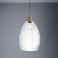 A long ribbed glass and antique brass metal pendant light. Perfect kitchen island light, or in a bedroom. Great in a hall will illuminate and add a glow to any room.