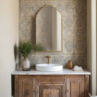 Gold gilt metal framed arched wall mirror, in a Moroccan style bathroom 