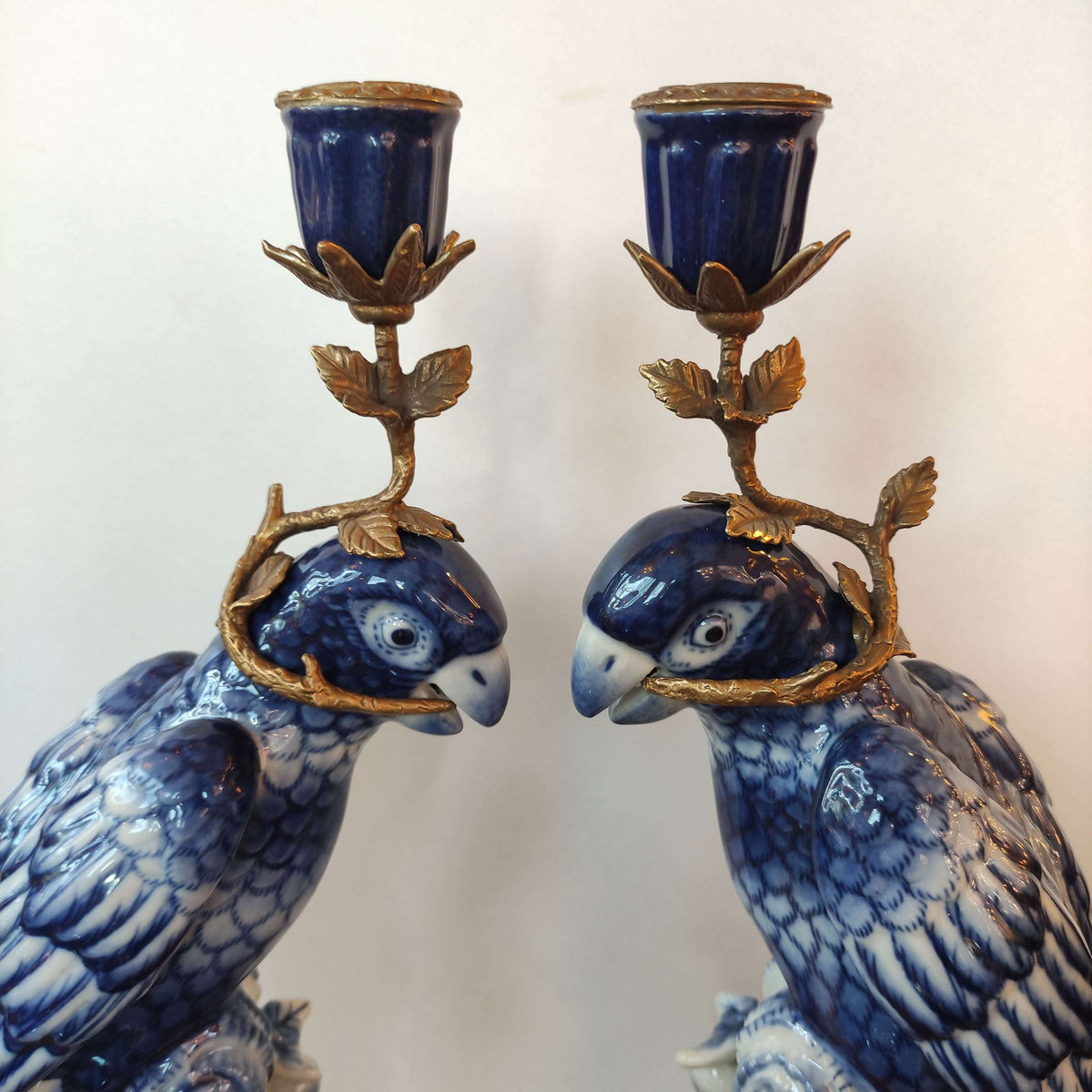 Bronze and porcelain parrot candle holders which are an exquisite reproduction of the Georgian originals. Beautifully made with the coloured porcelain parrots, topped with a bronze candle holder.