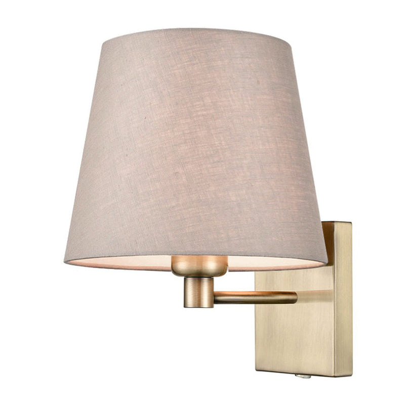 A contemporary wall light combining a brass metal frame with a softly tapered neutral linen shade 