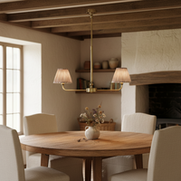 A refined ceiling light featuring an brass frame with two curved arms, each supporting a classic tapered fabric clip shade. 