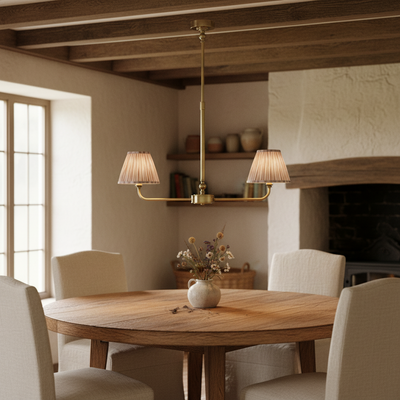 A refined ceiling light featuring an brass frame with two curved arms, each supporting a classic tapered fabric clip shade. 