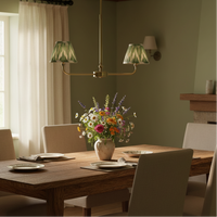 A refined ceiling light featuring an brass frame with two curved arms, each supporting a classic tapered fabric clip shade. 