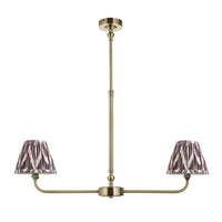 A refined ceiling light featuring an brass frame with two curved arms, each supporting a classic tapered fabric clip shade. 
