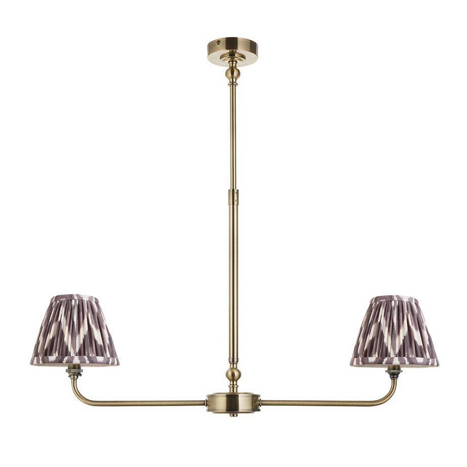 A refined ceiling light featuring an brass frame with two curved arms, each supporting a classic tapered fabric clip shade. 