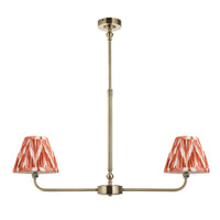 A refined ceiling light featuring an brass frame with two curved arms, each supporting a classic tapered fabric clip shade. 