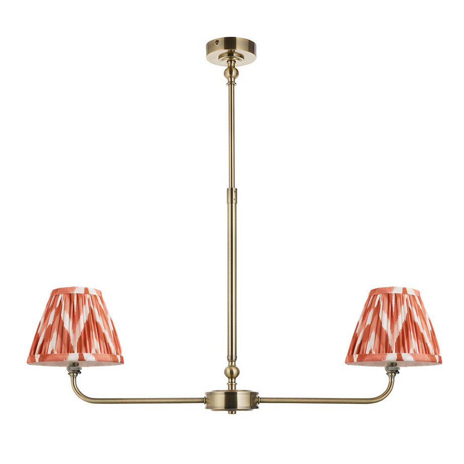 A refined ceiling light featuring an brass frame with two curved arms, each supporting a classic tapered fabric clip shade. 